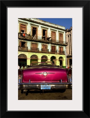 Classic 50's Buick in front of old worn and colorful apartment buildings, Havana, Cuba