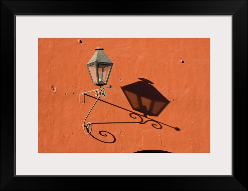 Central America, Guatemala, Antigua.  A lantern with shadow on a colorful wall in the town of Antigua.