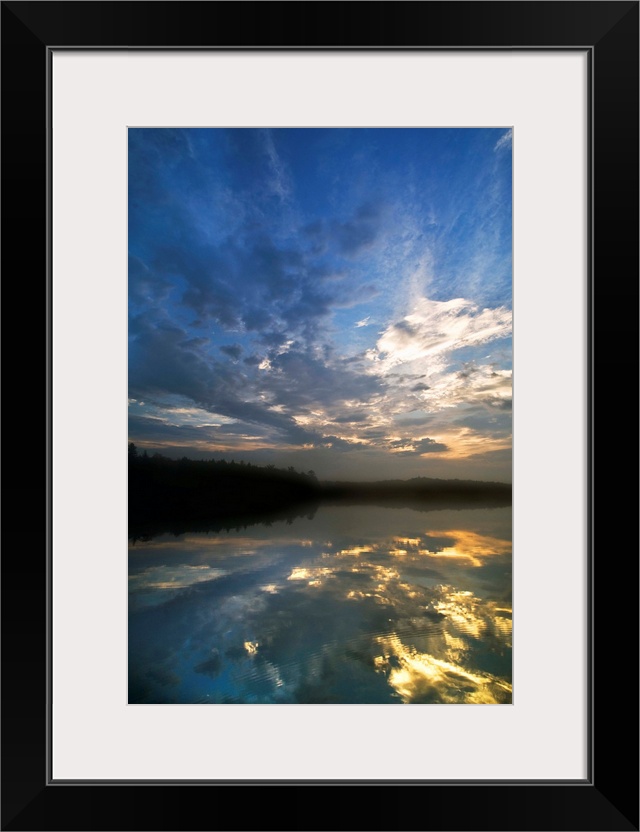 USA, Michigan, Upper Peninsula. Sunrise sky reflected in Pete's Lake.