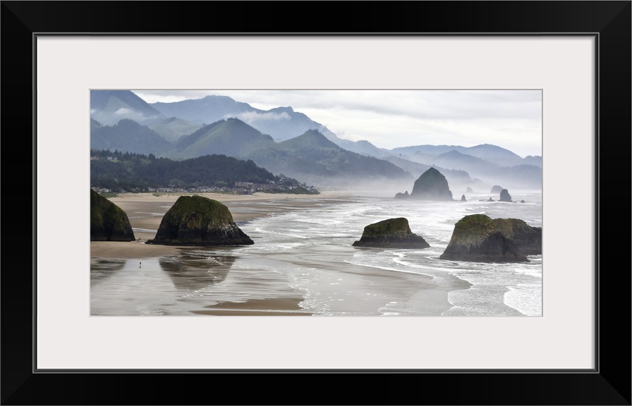 USA, Oregon, Cannon Beach. Fog rises over coastline at low tide.