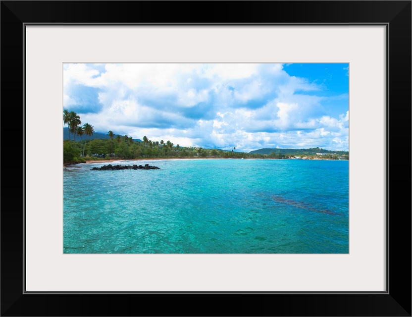 San Juan, Puerto Rico - Calm water is seen in the bay of a tropic island. Trees and beach can be seen in the background. H...