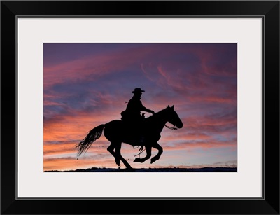 USA, Shell, Wyoming, Hideout Ranch Cowgirl Silhouetted On Horseback At Sunset