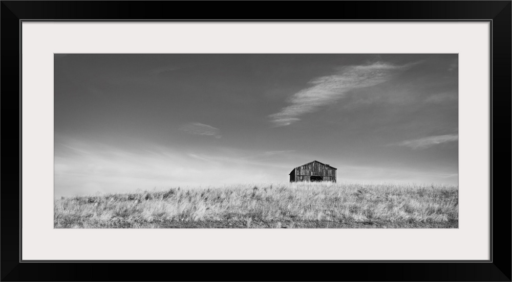 Barn on a hill in black and white.