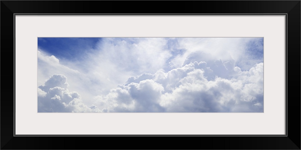 Panoramic shot of a blue sky with lots of fluffy clouds.