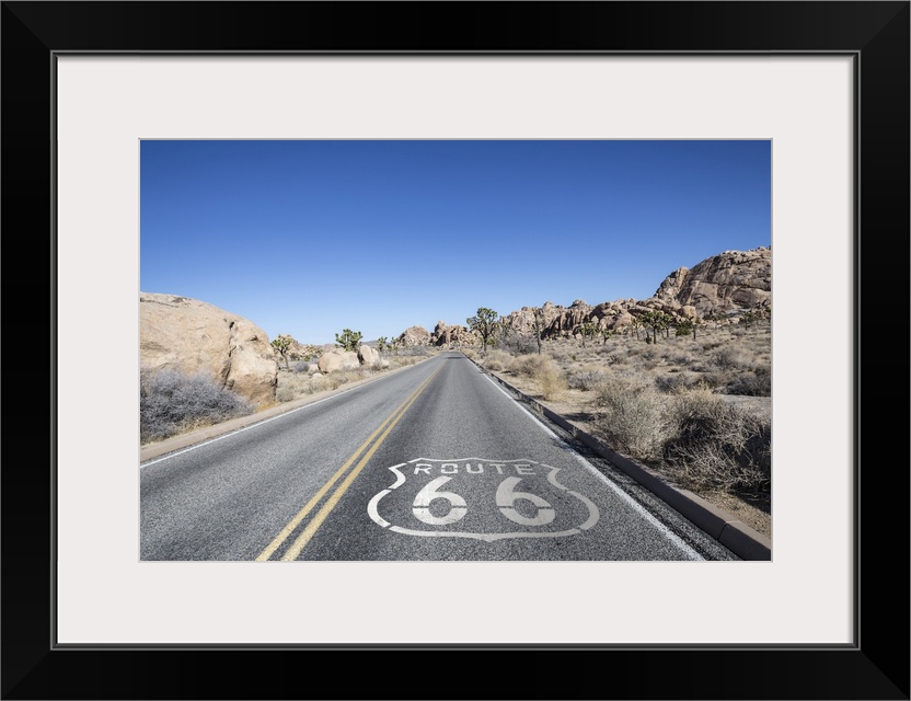 Joshua tree highway with route 66 pavement sign in Californiaos Mojave desert.