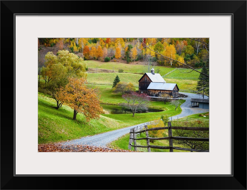 Fall foliage, New England countryside at Woodstock, Vermont, farm in autumn landscape. Old wooden barn surrounded by color...