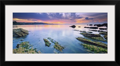 England, Cornwall, Rocks surfacing from the low tide seaside at dawn near Looe village