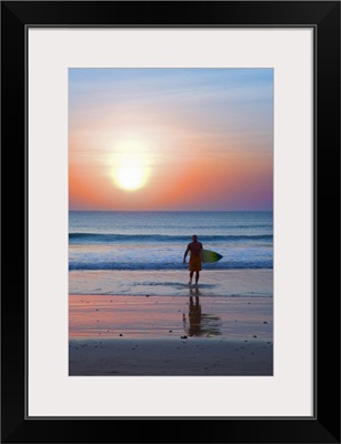 Indonesia, Bali, Jimbaran, Surfer on the beach at sunset