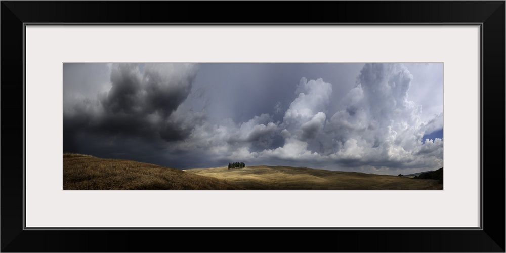 Italy, Tuscany, San Quirico d'Orcia, Storm over group of cypress trees.