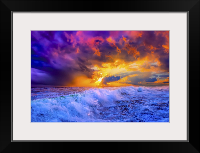 Sunlit waves crash through the ocean under a blue, red, purple, and golden sunset.