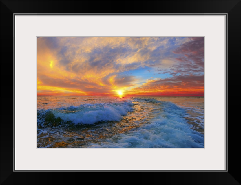 Ocean waves spiral through the sunset and up into a red and blue and golden sky.