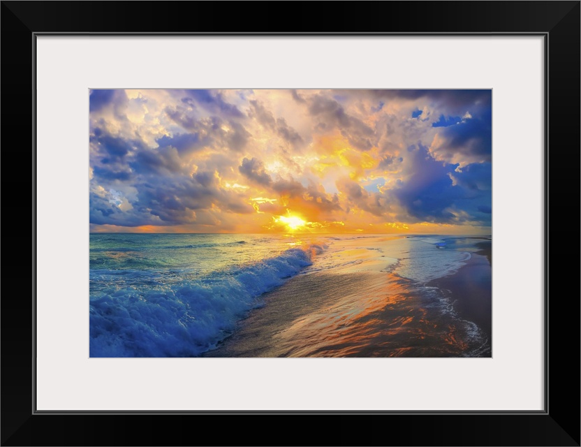 Soft heavenly white and pink clouds hover above a blue turquoise ocean. Waves break onto the beach.