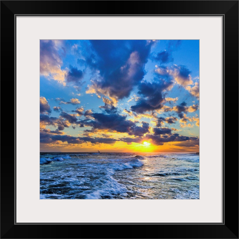 A Florida sunset with expanding puffy blue clouds during winter.