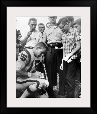 Buffalo Bills player Jack Kemp signs his autograph for a boy on August 4, 1964