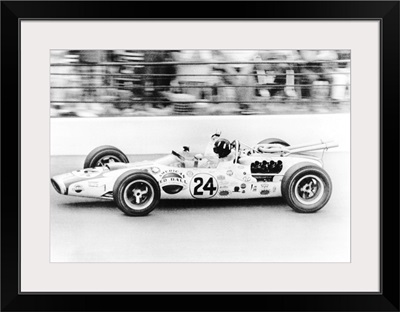 Graham Hill, waves as his car streaks toward the finish line to win the Indianapolis 500