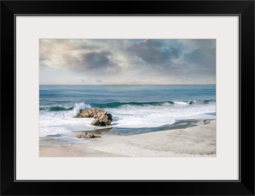 Landscape photograph of waves crashing onto a rock on the sandy shore.