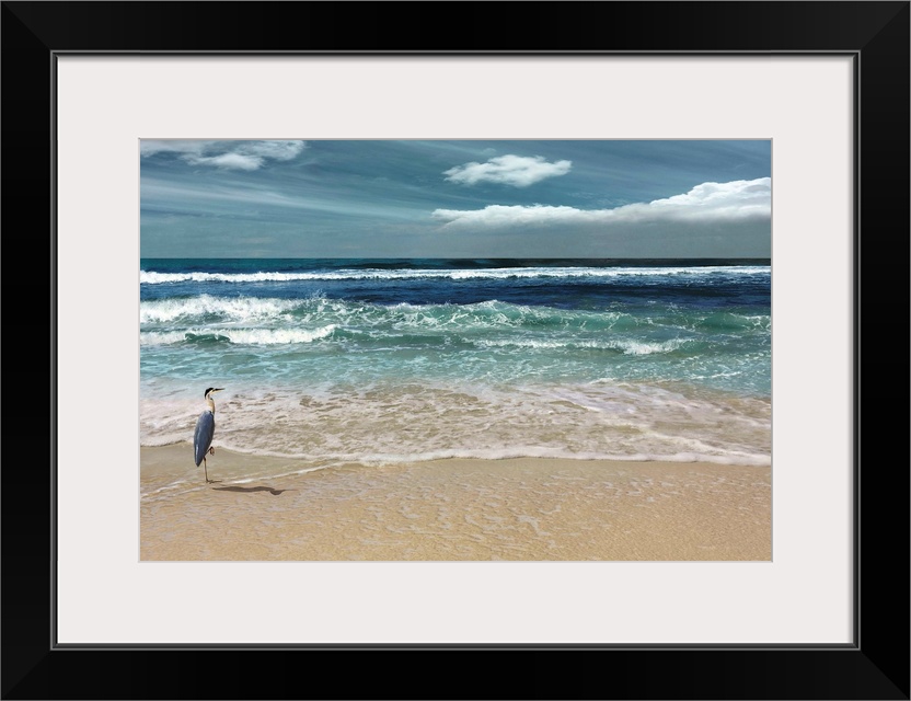 This serene photo shows rippling waves as they approach the heron on the beach with white clouds in the background.