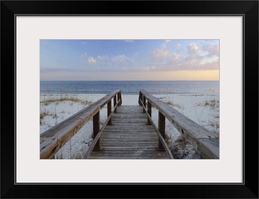 Photograph of a wooden walkway leading to the sandy beach with a Pensacola sunset