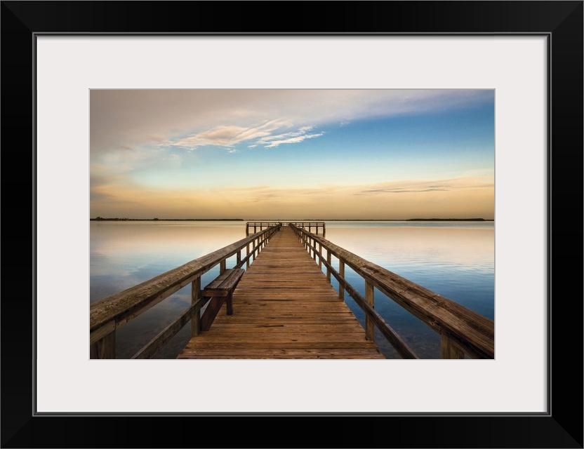Photograph of a long, wooden pier over the Terra Ceia Bay in Florida with a golden sunset.