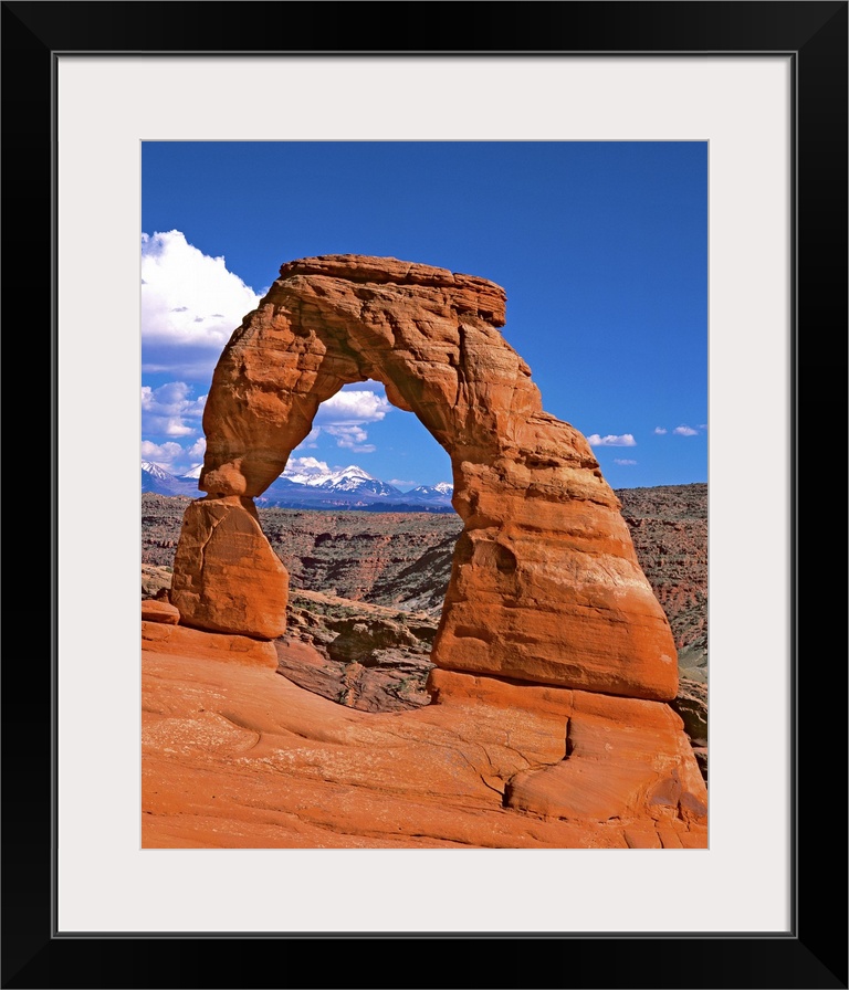 Bright red natural arch on a cliff in Arches National Park, Utah.