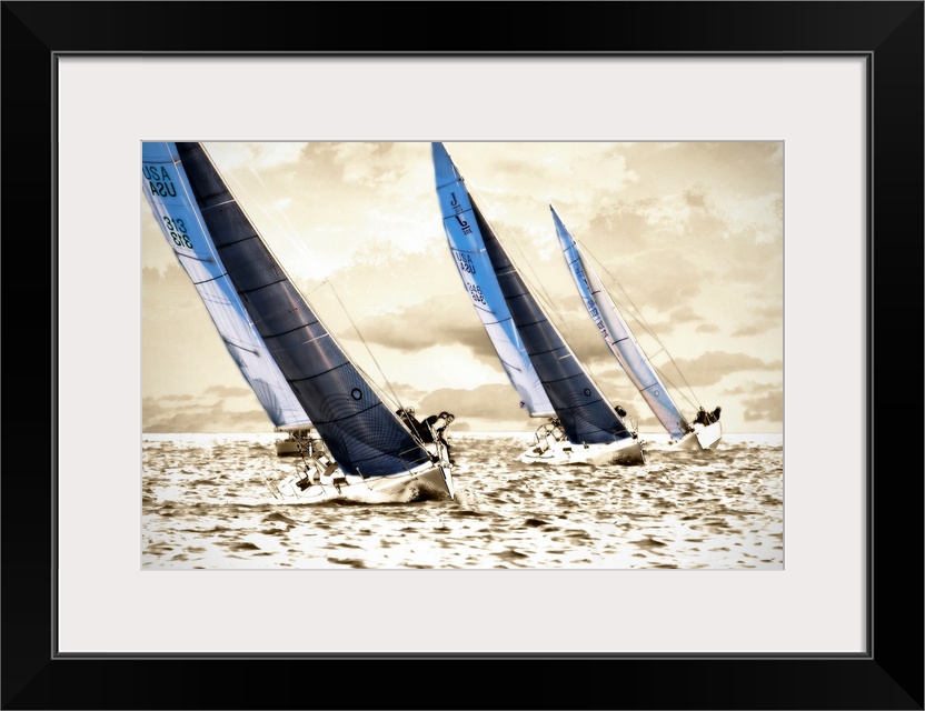 A photograph of three sailboats speeding through the water on a sunny day; this wall art has a bright monochromatic sea an...