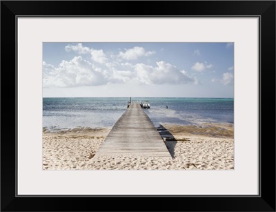 A long dock with a boat at the end, South Hole Sound on Little Cayman