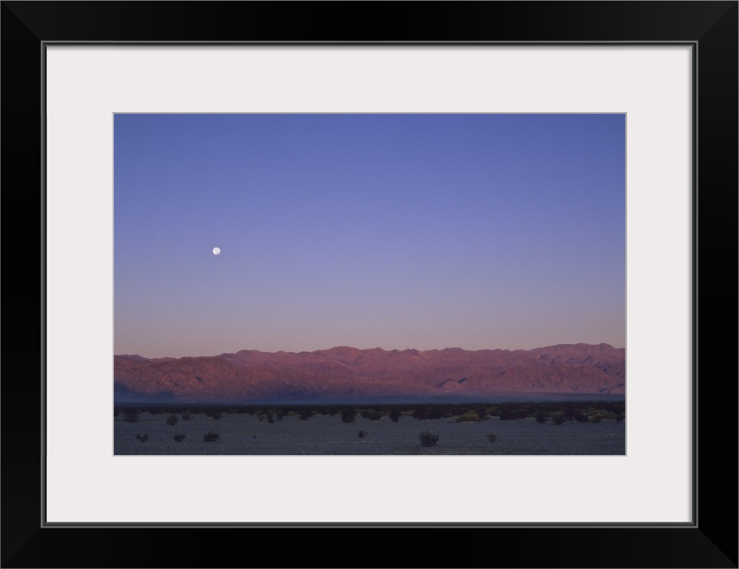 A moon above a mountain range in Death Valley National Park.