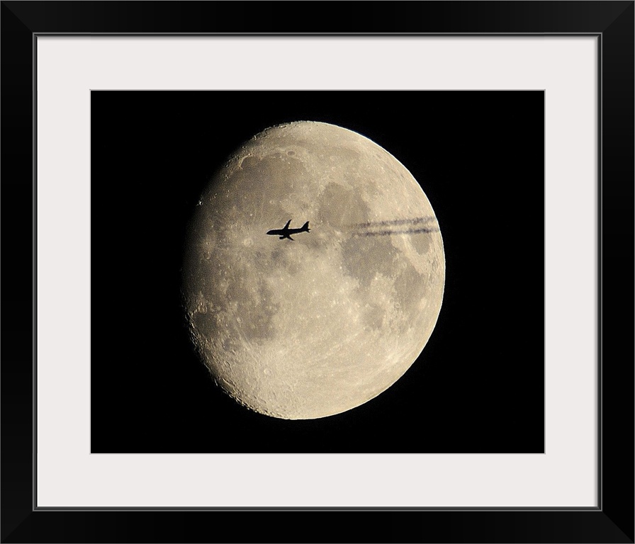 plane crossing in front of moon.