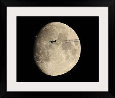 A plane in front of the moon