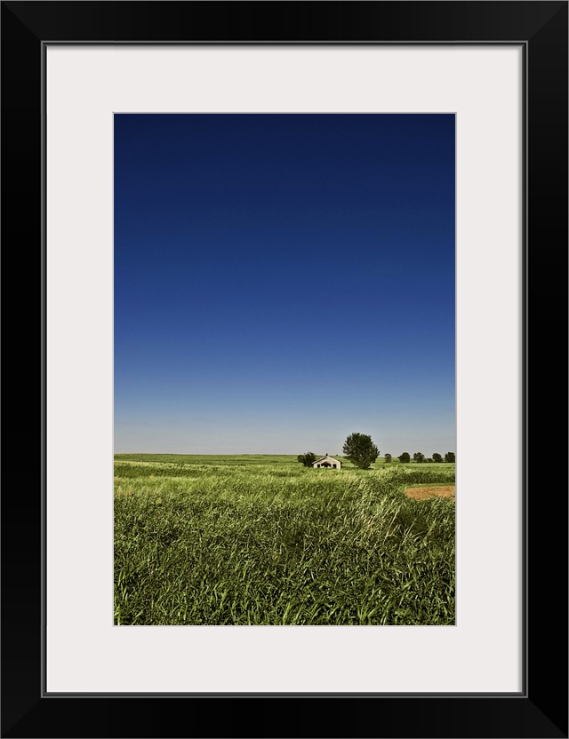 A long-abandoned house sits in a field in the desolate grassy plains of southwest Oklahoma.