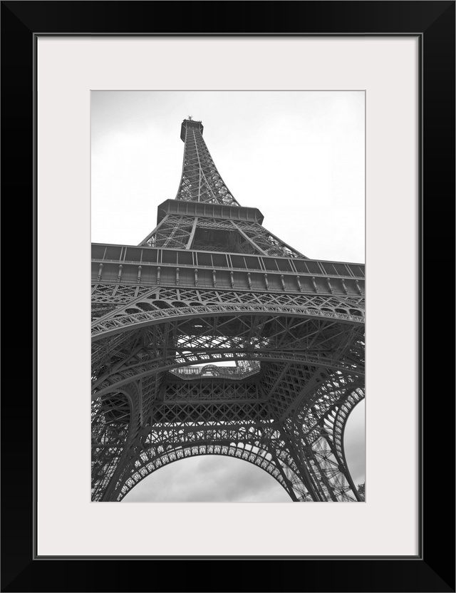 Black and white photograph of the Eiffel Tower looking up from underneath with dove flying above.