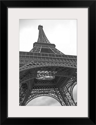 Black and white photograph of the Eiffel Tower looking up from underneath