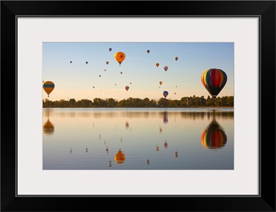 Colorful air balloons reflected in lake.