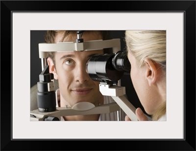 Doctor looking at eye with slit lamp
