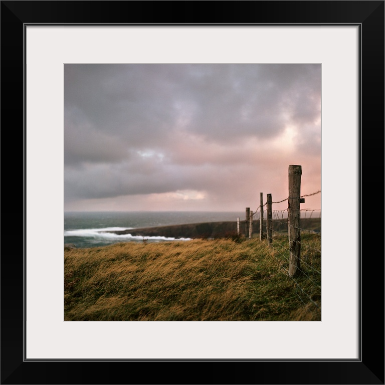 Fence stretches toward bloody foreland at sunrise in County Donegal, Ireland.