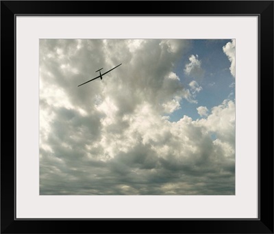 Glider in flight against cloudy sky, low angle view