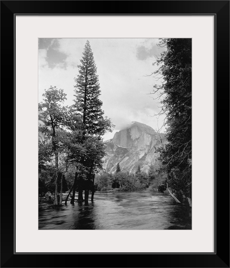 Half Dome, one of Yosemite Park's most familiar landmarks, rises beyond the Merced River.