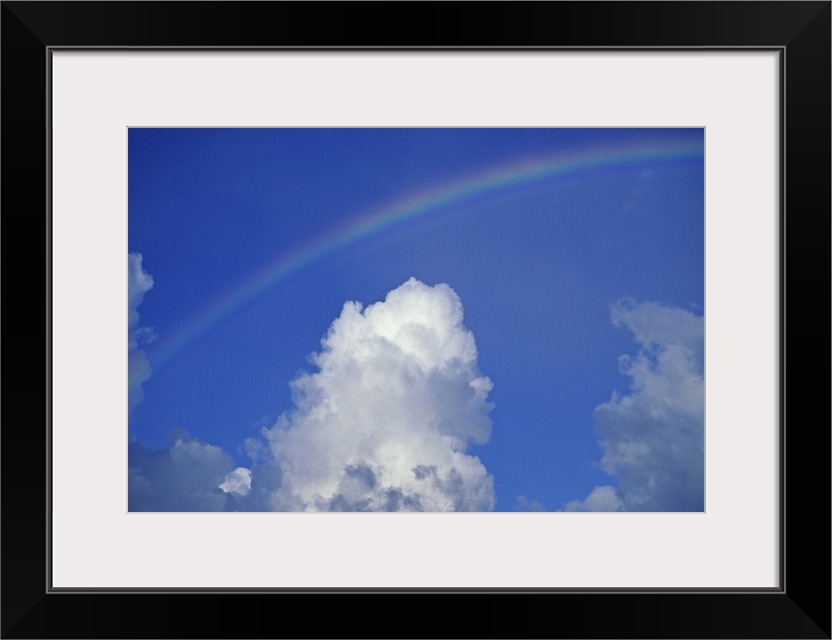 Hawaii, Rainbow arching over clouds in blue sky