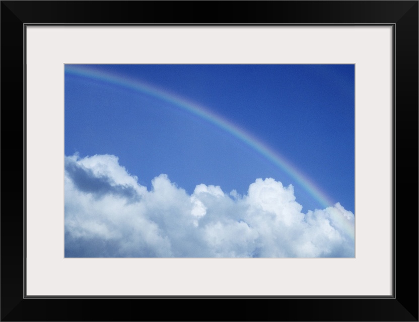 Hawaii, Rainbow arching over clouds in blue sky