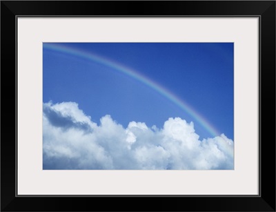 Hawaii, Rainbow arching over clouds in blue sky