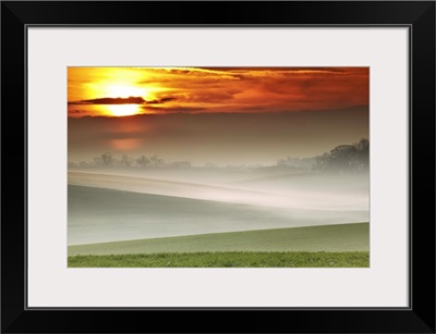 Mist over landscape of rolling hills at sunset, Exton, Rutland.
