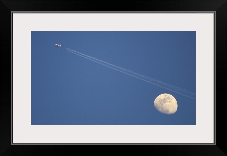 Moon and airplane in sky.