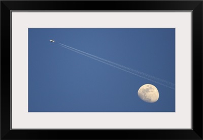 Moon and airplane in sky.
