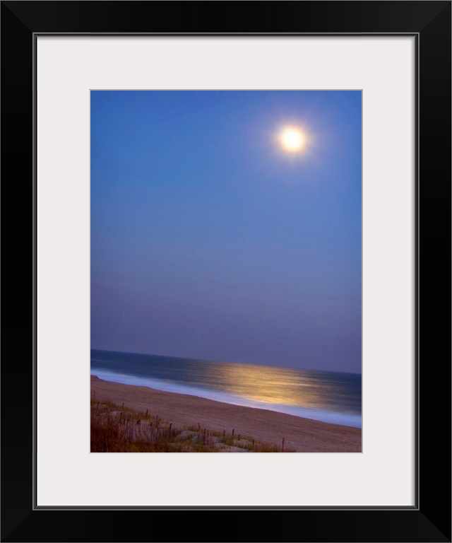 This large piece is a picture of the moon shining brightly over the beach and reflecting in the ocean.