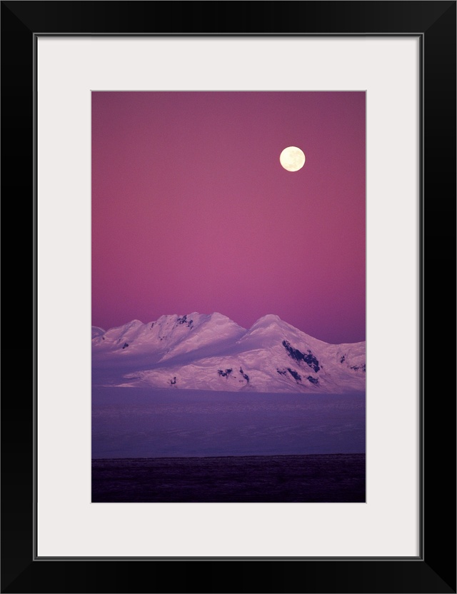 Moonrise over snowy mountain