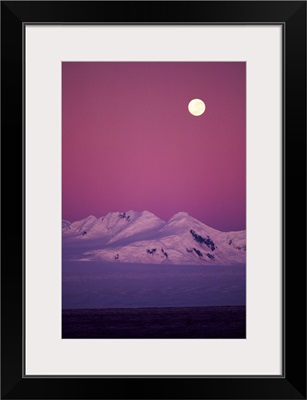 Moonrise over snowy mountain