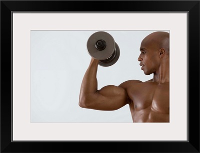 Muscular man lifting dumbbell