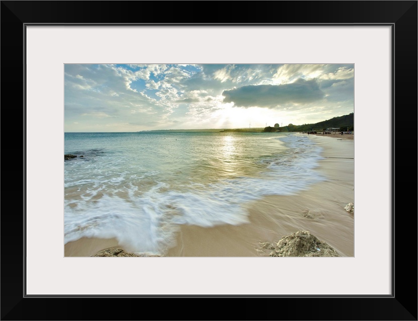 Nanwan, Kenting on  cloudy afternoon with foaming green sea water rushing in onto sandy beach with coral reefs and strong ...