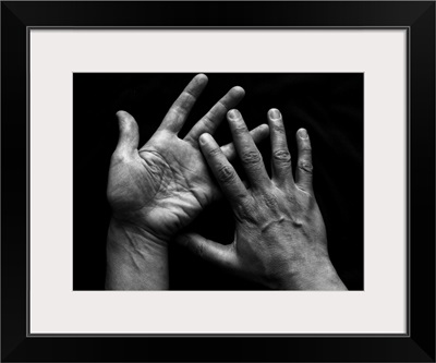 Pair of human hands on black background.
