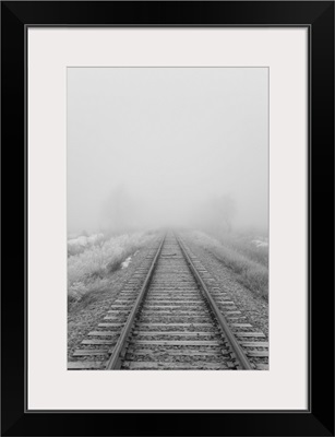 Railroad tracks fade into the morning fog